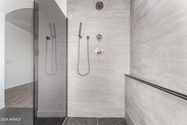 bathroom featuring tile patterned flooring and tiled shower