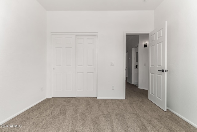 unfurnished bedroom featuring carpet flooring and a closet