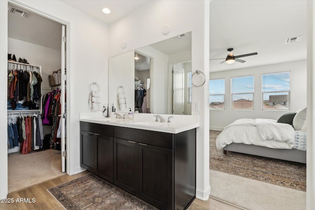 3919 W Abalone Ln, San Tan Valley, AZ 85144 - bathroom featuring double vanity, ceiling fan, wood finished floors, a walk in closet, and baseboards