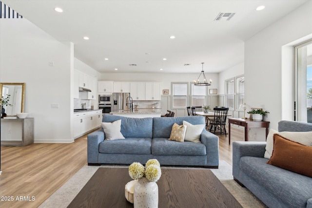 3919 W Abalone Ln, San Tan Valley, AZ 85144 - living area featuring light wood finished floors, recessed lighting, a chandelier, and baseboards