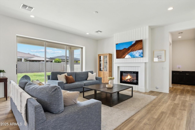 3919 W Abalone Ln, San Tan Valley, AZ 85144 - living room featuring light wood-style flooring, a glass covered fireplace, recessed lighting, and baseboards