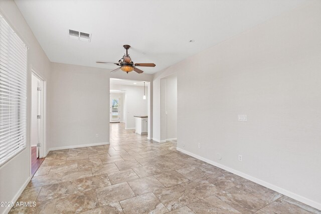 12727 W Lowden Rd, Peoria, AZ 85383 - unfurnished room featuring a ceiling fan, light stone finish floors, and baseboards