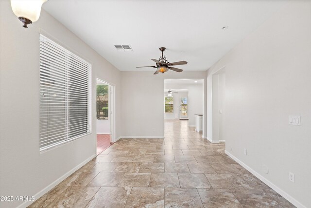 12727 W Lowden Rd, Peoria, AZ 85383 - empty room featuring ceiling fan, plenty of natural light, baseboards, and stone finish flooring