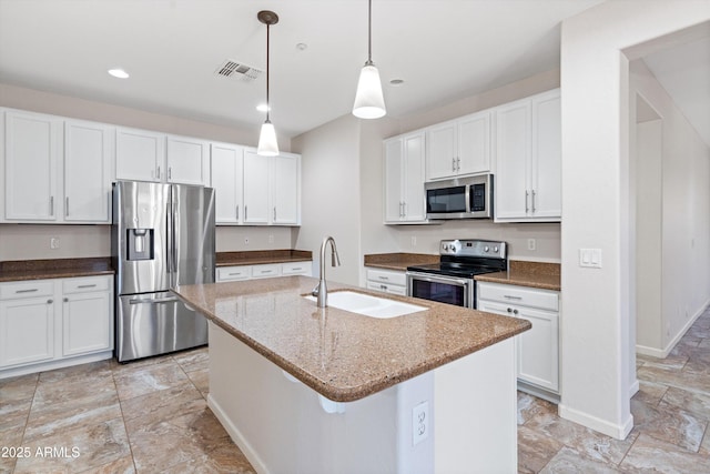 12727 W Lowden Rd, Peoria, AZ 85383 - kitchen with appliances with stainless steel finishes, a sink, white cabinets, dark stone countertops, and pendant lighting