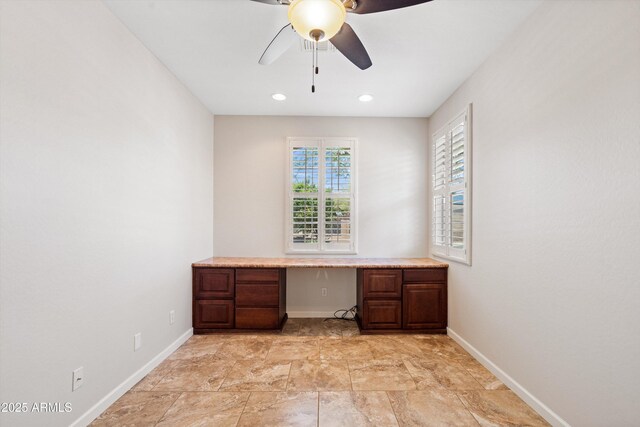 12727 W Lowden Rd, Peoria, AZ 85383 - unfurnished office with built in desk, a ceiling fan, baseboards, and light stone finish floors