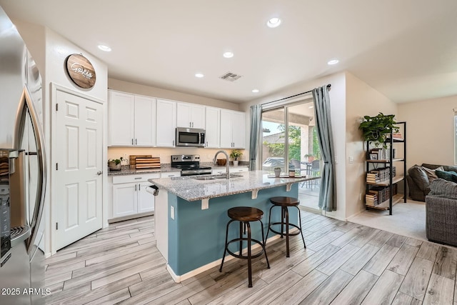 kitchen with light wood-type flooring, visible vents, appliances with stainless steel finishes, and a sink