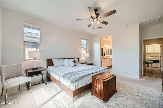 bedroom featuring ensuite bath, visible vents, baseboards, and light carpet