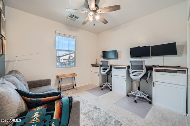office area featuring light colored carpet, a ceiling fan, and visible vents