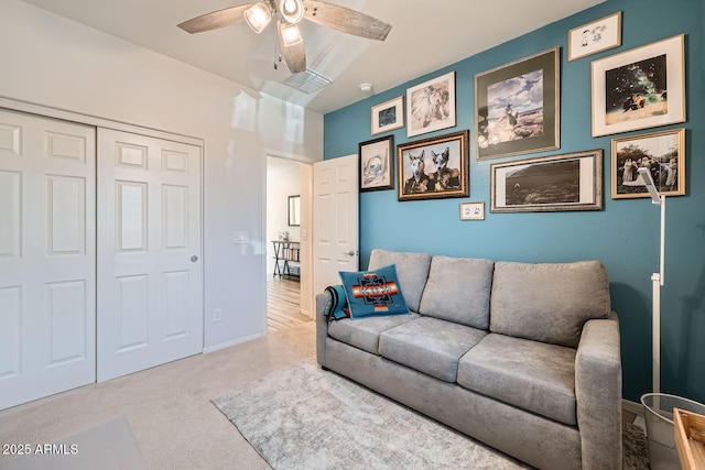 carpeted living area featuring baseboards, a ceiling fan, and visible vents