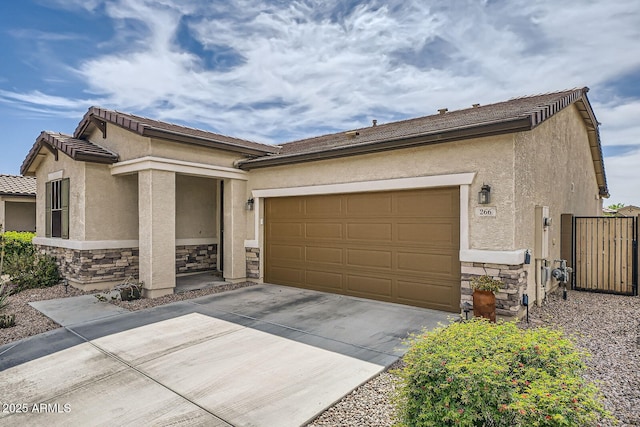 view of front of home with a garage, driveway, stone siding, and stucco siding