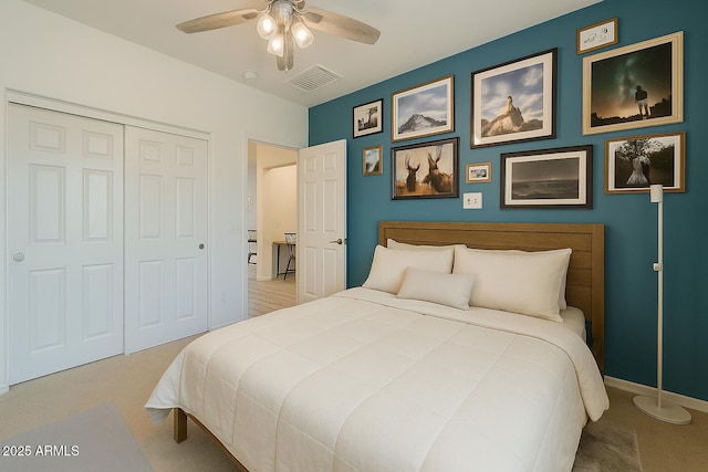 bedroom with baseboards, visible vents, carpet, a closet, and ceiling fan