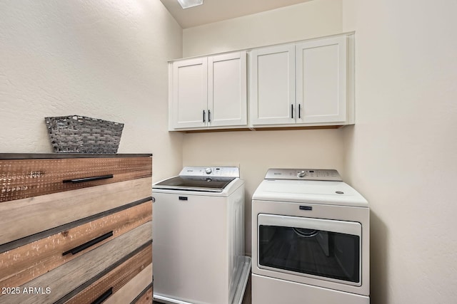 washroom featuring cabinet space and washing machine and clothes dryer
