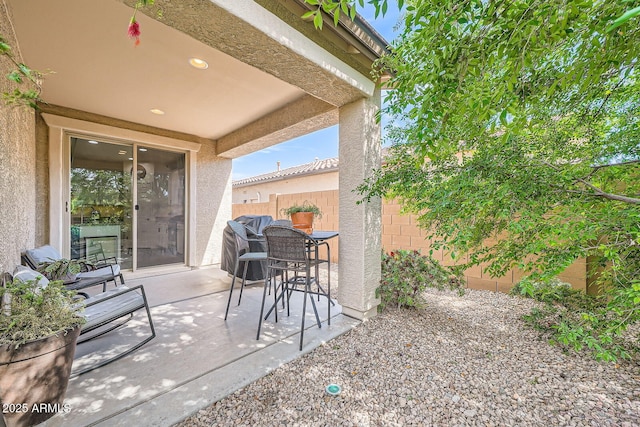 view of patio with outdoor dining area and fence