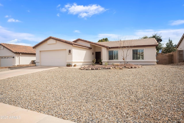 ranch-style home with driveway, an attached garage, a tiled roof, and stucco siding