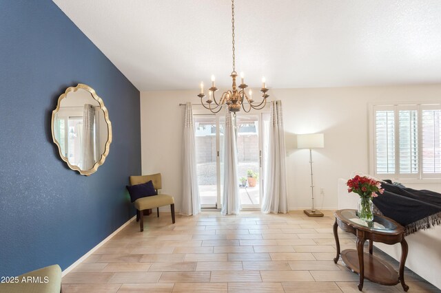 living area featuring a healthy amount of sunlight, baseboards, and a chandelier