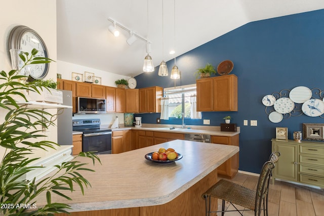 kitchen featuring lofted ceiling, stainless steel appliances, a sink, and light countertops