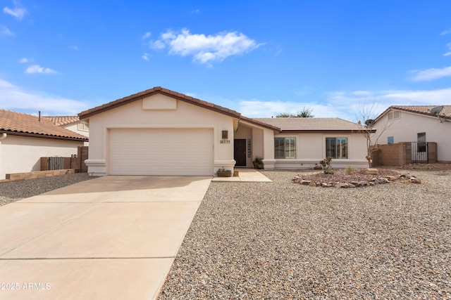 ranch-style home featuring a garage, fence, concrete driveway, a tiled roof, and stucco siding