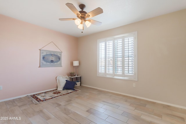 spare room featuring baseboards and a ceiling fan