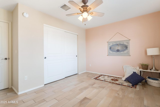 unfurnished room with baseboards, visible vents, ceiling fan, and light wood finished floors