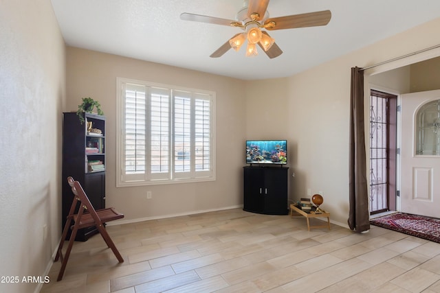 unfurnished room featuring ceiling fan, light wood-style flooring, and baseboards