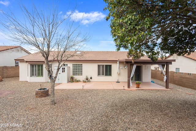 back of property featuring a tiled roof, a patio area, a fenced backyard, and stucco siding