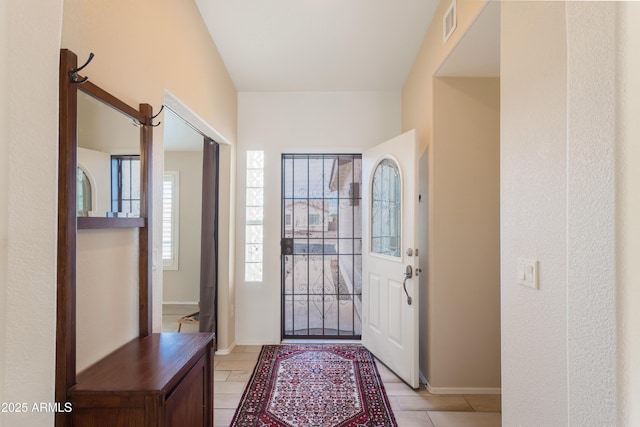 foyer entrance with baseboards and visible vents