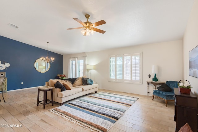 living area featuring ceiling fan with notable chandelier, light wood-type flooring, visible vents, and baseboards