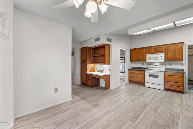 kitchen featuring white appliances, light hardwood / wood-style floors, and a textured ceiling