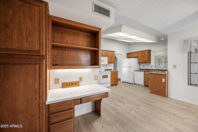 kitchen featuring sink, white appliances, a textured ceiling, and light wood-type flooring