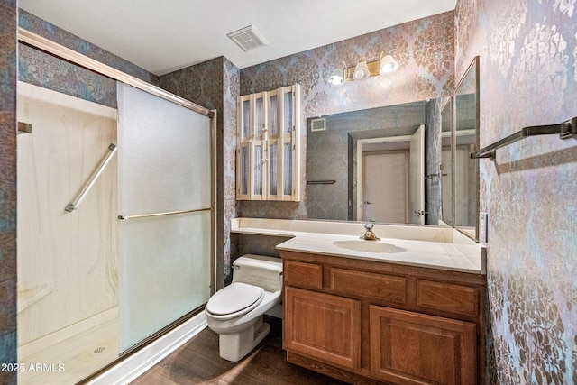 bathroom featuring a shower with shower door, wood-type flooring, toilet, and vanity