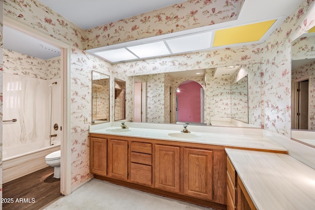 full bathroom with toilet, washtub / shower combination, a skylight, and vanity