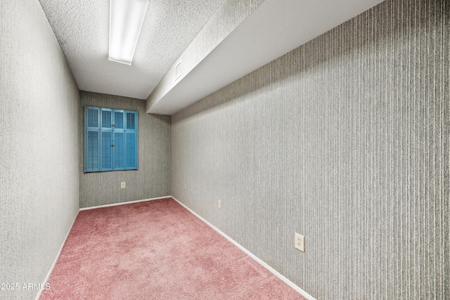 empty room with carpet floors and a textured ceiling