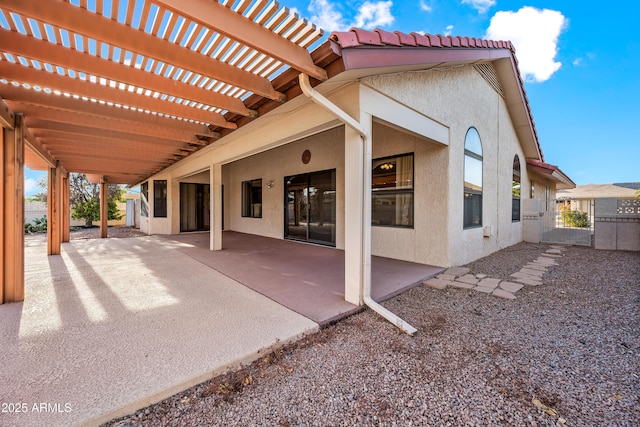 back of property featuring a patio area and a pergola