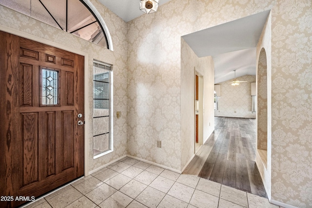 entryway with plenty of natural light, light tile patterned floors, and ceiling fan