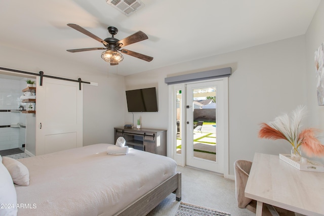 bedroom featuring ceiling fan, a barn door, access to exterior, and light carpet