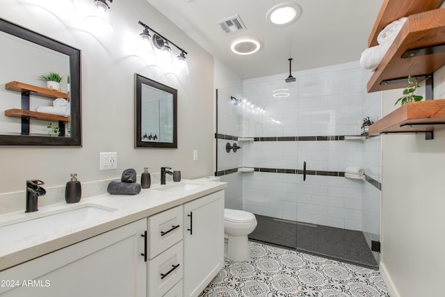 bathroom with tile patterned flooring, vanity, a shower with shower door, and toilet