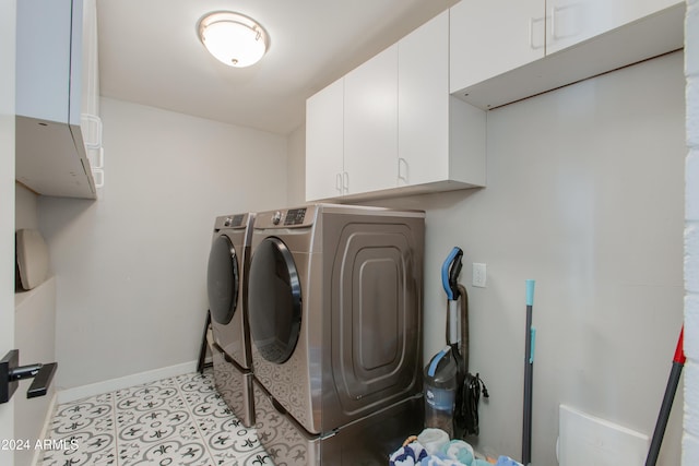 washroom featuring cabinets and washing machine and dryer