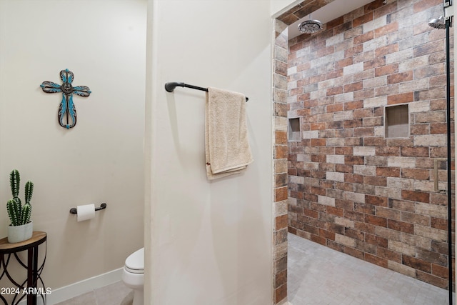 bathroom featuring tiled shower, tile patterned flooring, and toilet