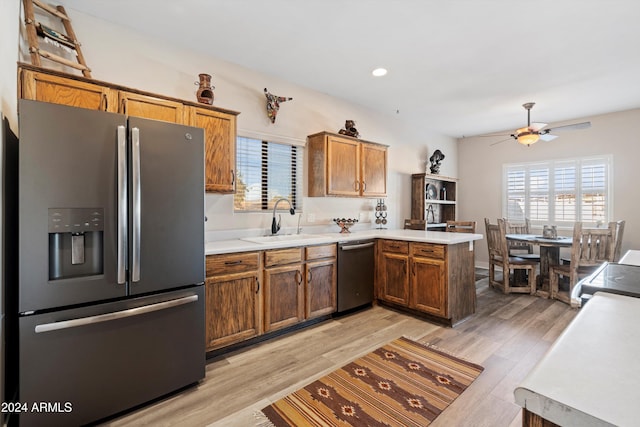 kitchen featuring ceiling fan, sink, kitchen peninsula, appliances with stainless steel finishes, and light wood-type flooring