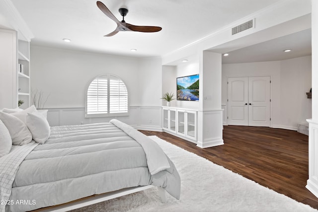 bedroom with ceiling fan, crown molding, and dark hardwood / wood-style flooring