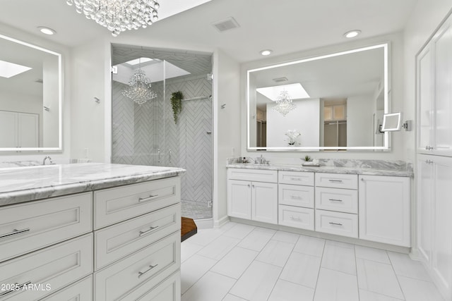 bathroom featuring tile patterned floors, walk in shower, vanity, and an inviting chandelier