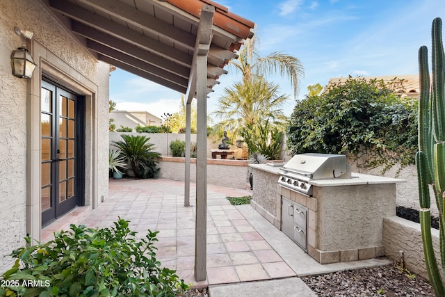 view of patio featuring a grill, an outdoor kitchen, and french doors