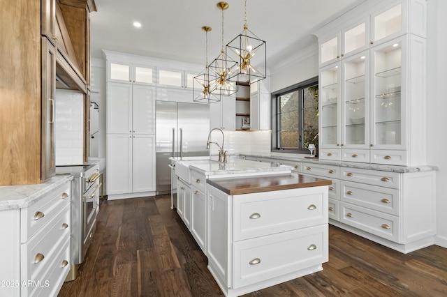 kitchen with white cabinets, a center island with sink, and premium appliances