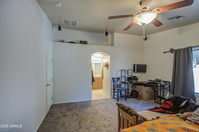 bedroom featuring ensuite bathroom, carpet, and ceiling fan