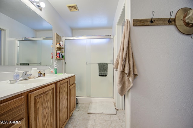 bathroom featuring vanity, a shower with shower door, and tile patterned floors