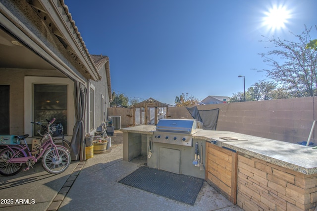 view of patio / terrace with area for grilling, a grill, and central air condition unit