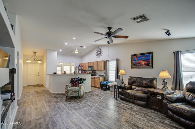 living room with wood-type flooring, ceiling fan, and vaulted ceiling