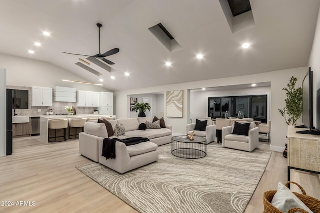 living room with light hardwood / wood-style floors, high vaulted ceiling, and ceiling fan