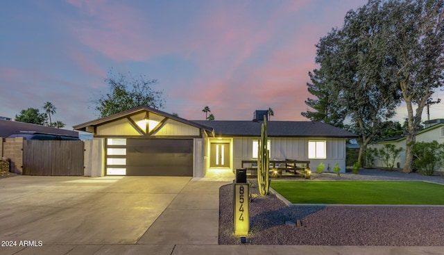 single story home featuring a yard and a garage