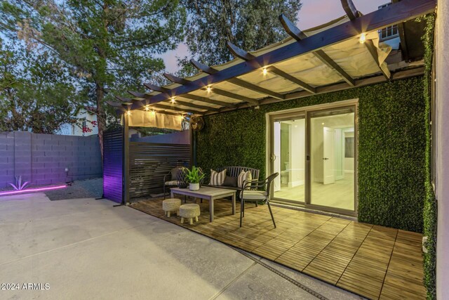 patio terrace at dusk featuring a pergola